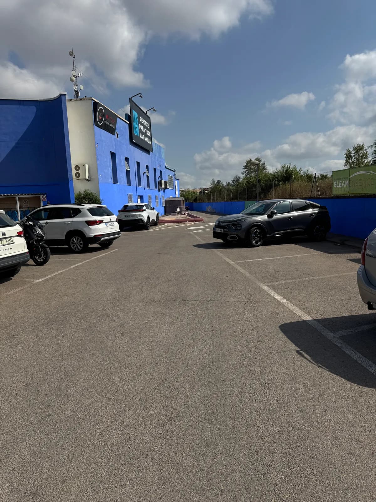 Parking principal de Tenisquash, con el edificio azul a la izquierda al entrar