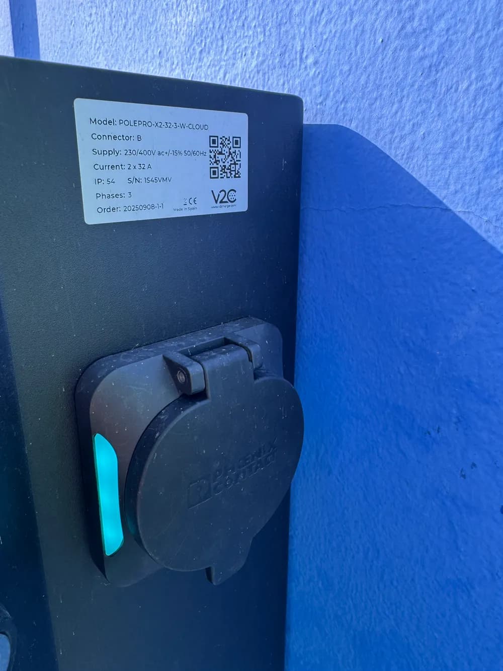 Toma Type 2 del poste de recarga, con la placa de características a la vista