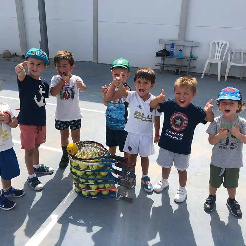 Niños del campus con raquetas de tenis en Alzira